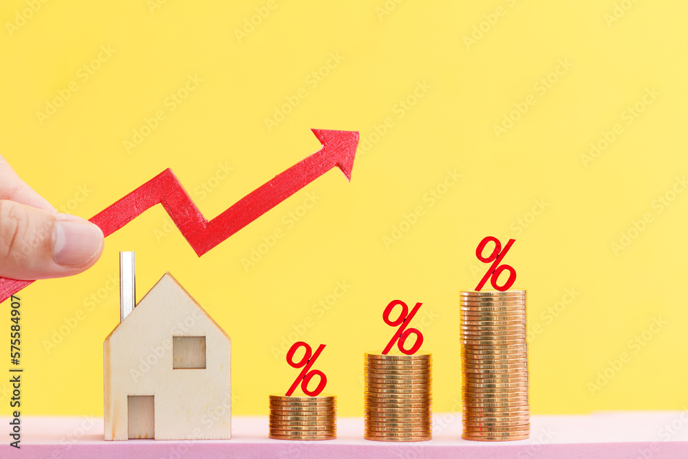 Woman hand hold a red arrow graph and home and percent put on the stack gold coin on bright yellow color background, Saving money for buy house and loan to business investment for real estate concept. - obrazy, fototapety, plakaty 