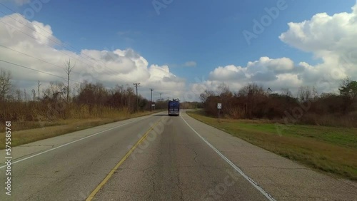 Point Of View Big Commercial Bus Moving On Road Amidst Bare Trees Under Cloudy Sky - New Orleans, Louisiana