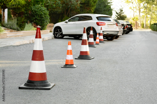 Traffic cones near cars on asphalt outdoors