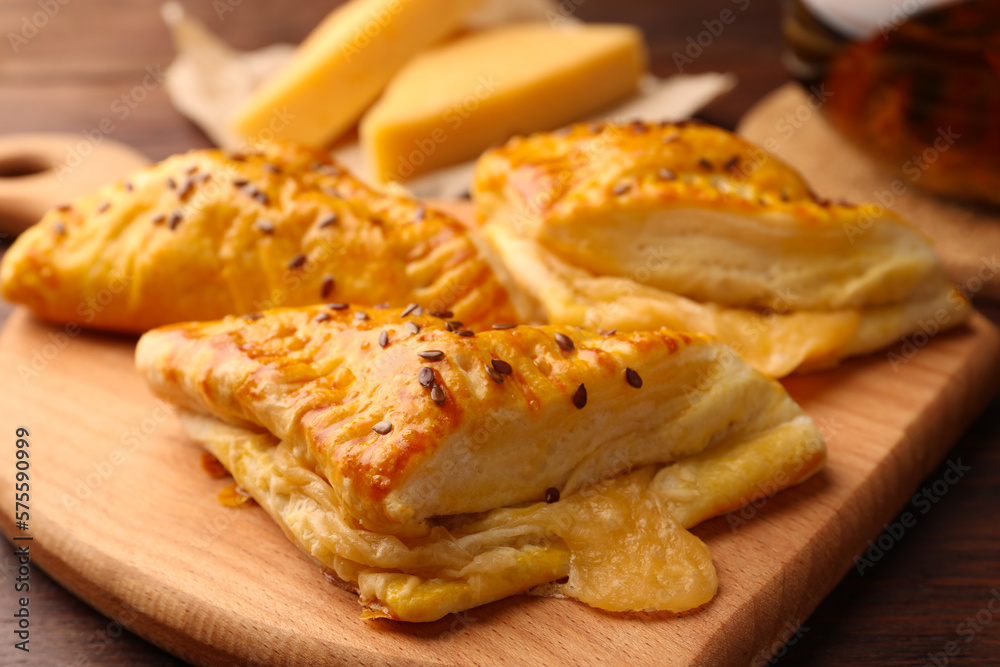 Fresh delicious puff pastry with cheese on wooden table, closeup Fresh delicious puff pastry with cheese on wooden table, closeup