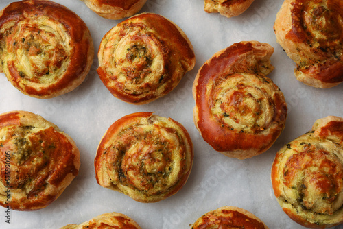 Fresh delicious puff pastry with tasty filling on parchment, flat lay