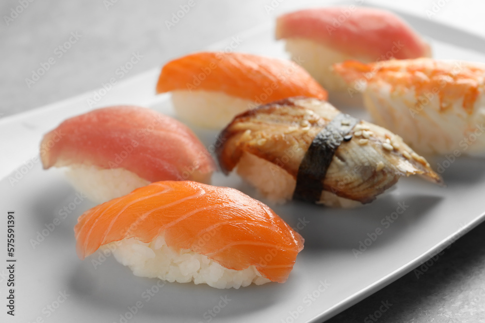 Plate with delicious nigiri sushi on grey table, closeup Plate with delicious nigiri sushi on grey table, closeup