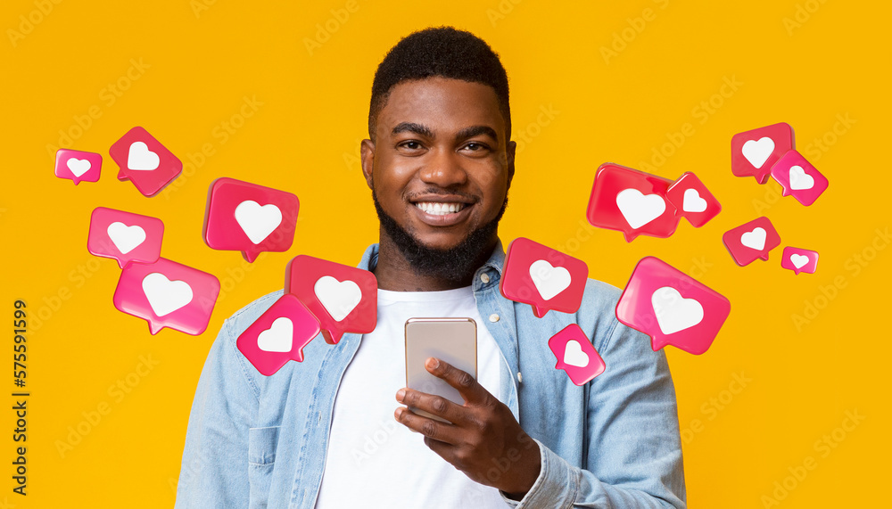Glad black adult man with beard has romantic chat with hearts on smartphone enjoys message, social networks - obrazy, fototapety, plakaty 