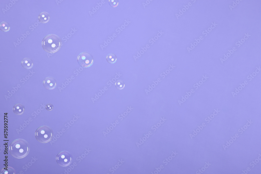 Many beautiful soap bubbles on violet background. Space for text