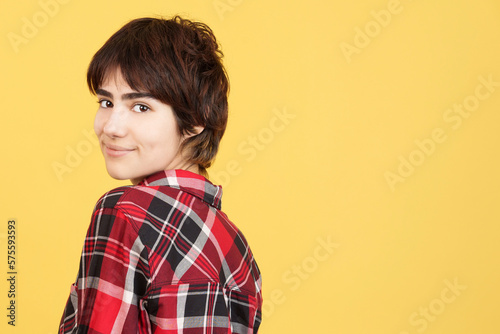 Androgynous person turning to smile at the camera