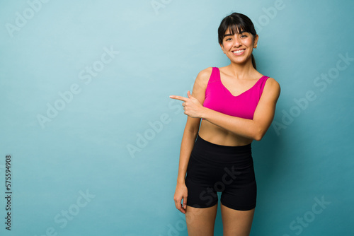 Active fitness trainer pointing to copy space