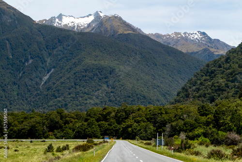 Winding and scenic road in New Zealand, with mountains and blue sky