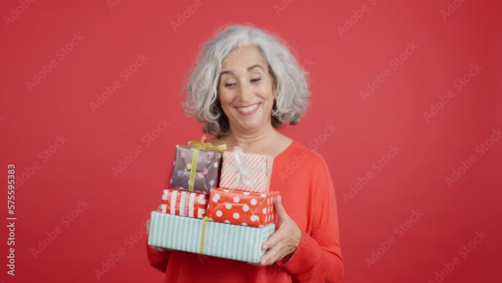 An excited mature woman receiving many gifts An excited mature woman receiving many gifts