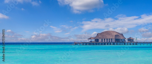 Best tranquil Maldives island, luxury over water villas resort aerial view. Beautiful sunny sky. Sea bay lagoon beach background. Summer vacation holiday. Paradise shore exotic landscape pristine blue