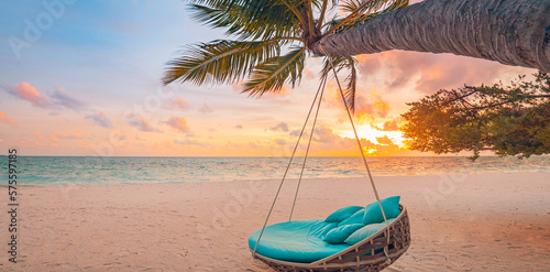 Romantic beach sunset. Palm tree with swing hanging before majestic clouds sky. Dream nature landscape, tropical island paradise, couple destination. Love coast, closeup sea sand. Relax pristine beach