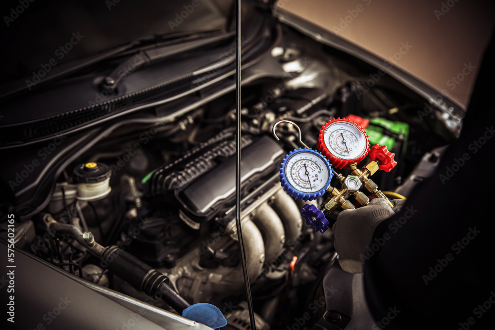 Car care maintenance and service, Hand technician auto mechanic using measuring manifold gauge check refrigerant and filling car air conditioner to fix repairing heat conditioning system.