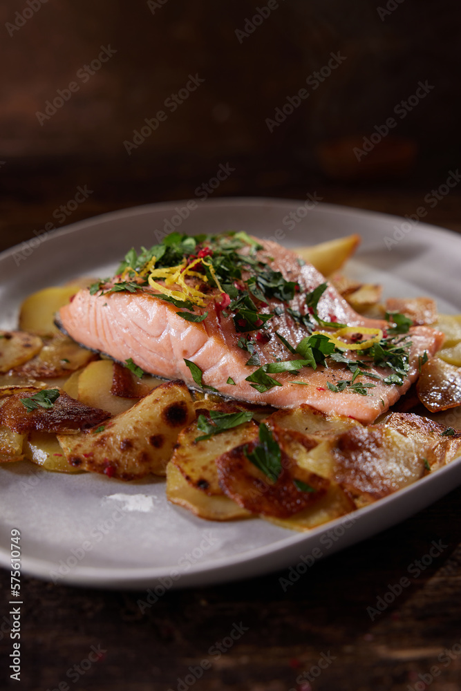 Served salmon steak with potatoes placed on table Served salmon steak with potatoes placed on table