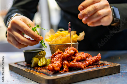 chef cookind chicken breast strips and french fries on restaurant kitchen