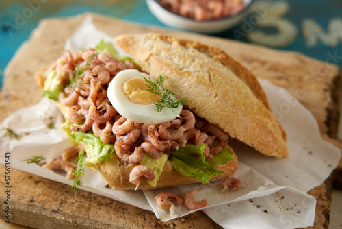 Healthy sandwich with shrimps and egg on wooden board