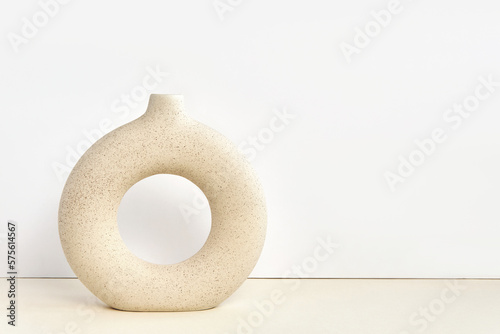 Stylish Circle Round Ceramic Vase on a Table. Detail of Contemporary Cozy Interior. Blank Space for Text on the Wall. Nordic Beige Background. Minimalistic Scandinavian Style. Empty Mockup