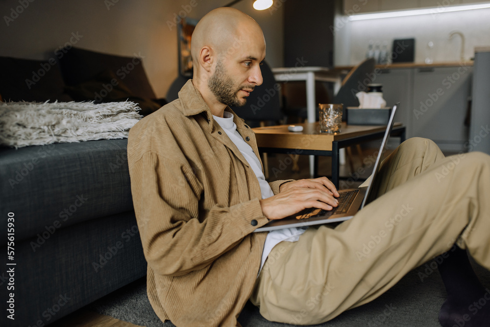 Freelancer at home working on modern laptop while sitting in living room at home. Remote work, IT specialist, designer, student Freelancer at home working on modern laptop while sitting in living room at home. Remote work, IT specialist, designer, student