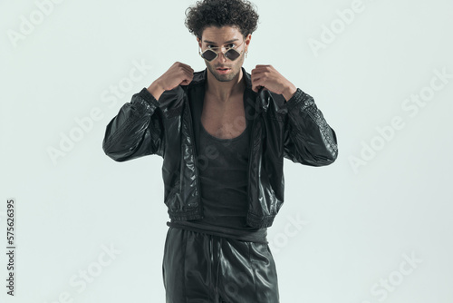casual man arranging his leather jacket