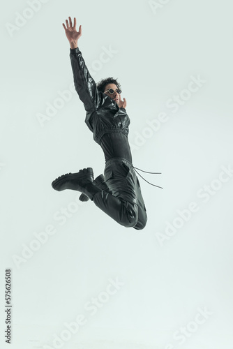 casual man jumping and kicking with hands up