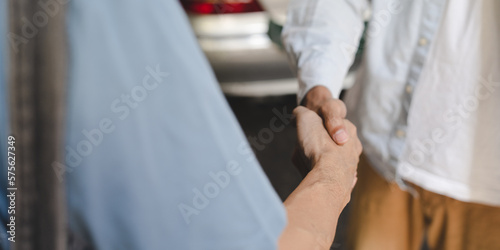 Mechanic technician man shaking hands with customer after finish checking the car at the garage, two people handshake for a working job at professional auto car repair service center