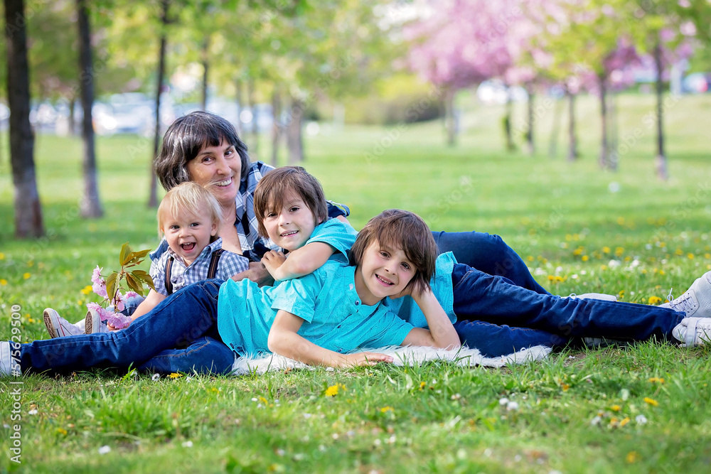 Cute children in the park with grandmother, springtime Cute children in the park with grandmother, springtime