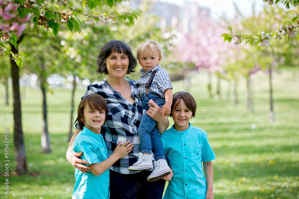 Cute children in the park with grandmother, springtime Cute children in the park with grandmother, springtime