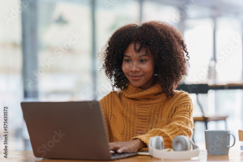 Young black African woman university student learning online using laptop computer. Smiling girl watch webinar or virtual education