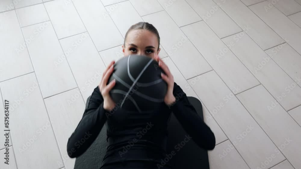 Fit attractive woman doing core abdominal workout exercises with a medicine ball, determined woman training in the gym to achieve your fitness goals Fit attractive woman doing core abdominal workout exercises with a medicine ball, determined woman training in the gym to achieve your fitness goals