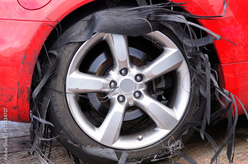 Torn tyre of a damaged sport car after race