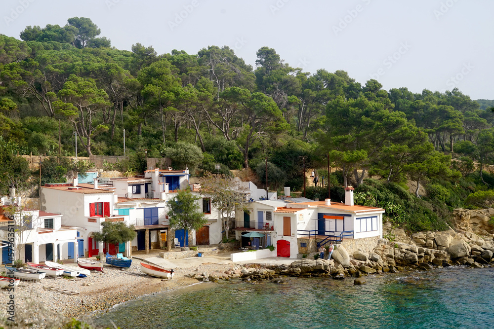 Cala s'Alguer, bay with old white fishing huts with colorful windows and door at the Mediterranean Sea, Costa Brava, Palamos, Catalonia, Spain