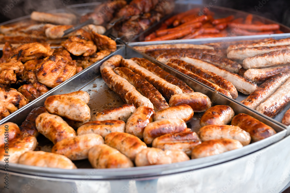 Tasty hot grilled sausages, chicken wings and barbecue in street market ready to eat
