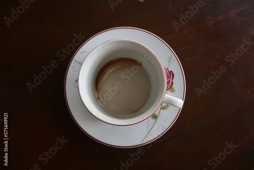 An empty cup of coffee on a wooden table © Mahfudh