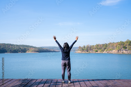Happy young woman enjoying at mountain lake. © natara