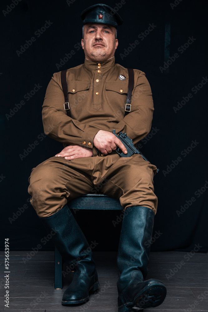 Soldier of the Russian army of the 20th century. Civil service officer in a cap, military uniform and with a pistol. A man with bristles and a strong-willed character. Soldier of the Russian army of the 20th century. Civil service officer in a cap, military uniform and with a pistol. A man with bristles and a strong-willed character.