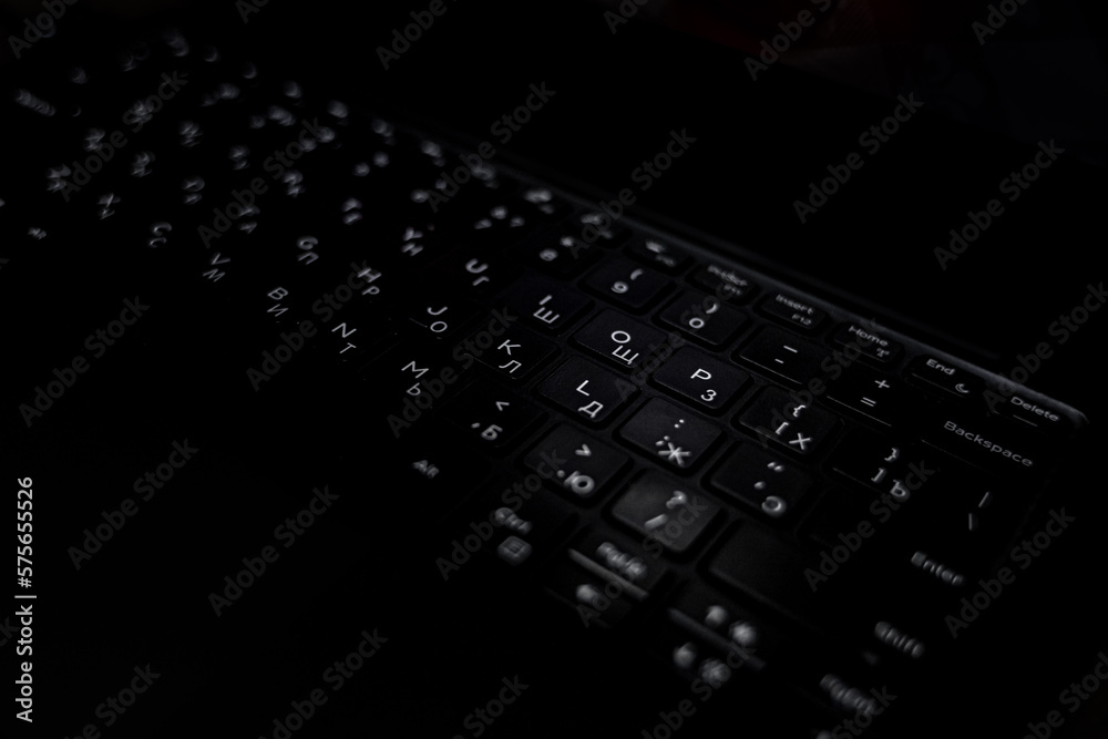 Black keyboard. White letters on a black background. Work on a laptop. Remote work. Modern technology.