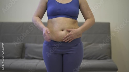Abdominal massage, tummy tuck and flabby skin on a fat belly, woman doing self-massage, plastic surgery concept