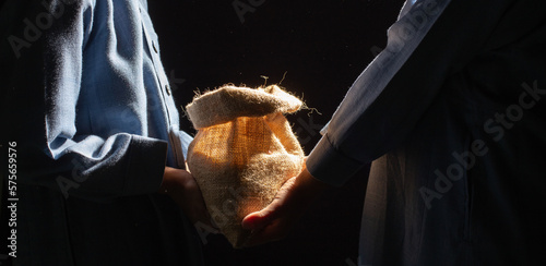Islamic zakat concept, holding alms bag of rice, ZAKAT donation for Muslims according to religious principles during the Ramadan month,
background copy space, Zakat  to fitnah