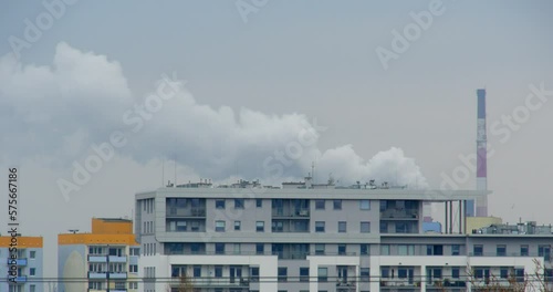 Dymiący komin przemysłowy. Smog, para wodna z ciepłowni lub innego przemysłu.  photo