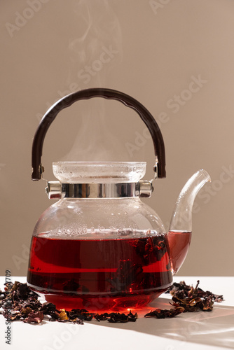 Red hibiscus tea from the petals of a Sudanese rose in a glass teapot