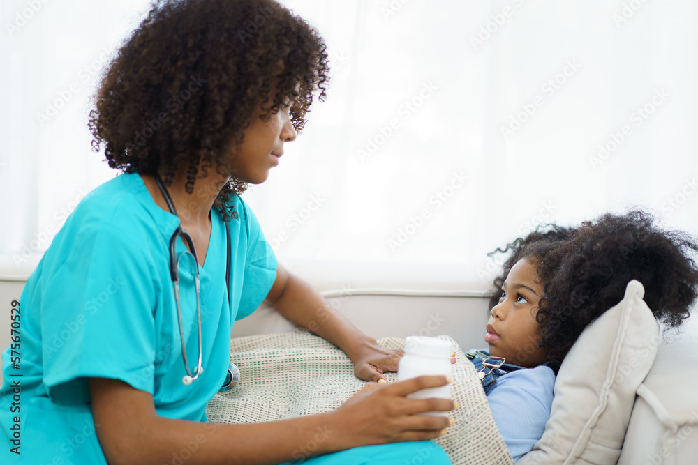 African American ethnicity female doctor and little girl in hospital, pediatrician taking to a little girl who laying down on the bed or sofa in hospital to talk about her sickness. African American ethnicity female doctor and little girl in hospital, pediatrician taking to a little girl who laying down on the bed or sofa in hospital to talk about her sickness.