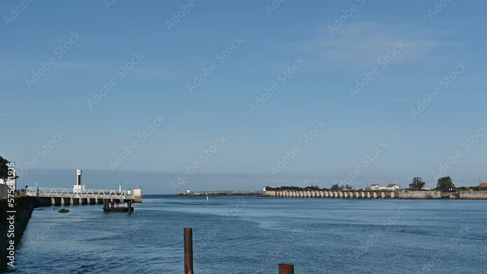 Mouth of the Adour river in Bayonne France the water flows calmly towards the sea on a lonely winter day