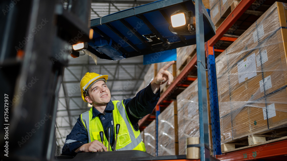 Engineer worker in a warehouse hard hat working. walking through logistics center warehouse factory construction site logistics forklift driver man. Engineer worker in a warehouse hard hat working. walking through logistics center warehouse factory construction site logistics forklift driver man.