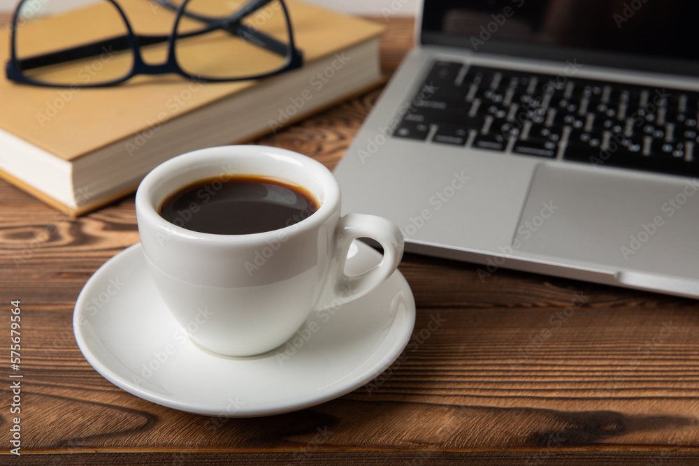 Desk with laptop, glasses, notepads and a cup of coffee on the desktop.Workspace with copy space. Mocap. Business concept. Place for text. Flat lay Desk with laptop, glasses, notepads and a cup of coffee on the desktop.Workspace with copy space. Mocap. Business concept. Place for text. Flat lay