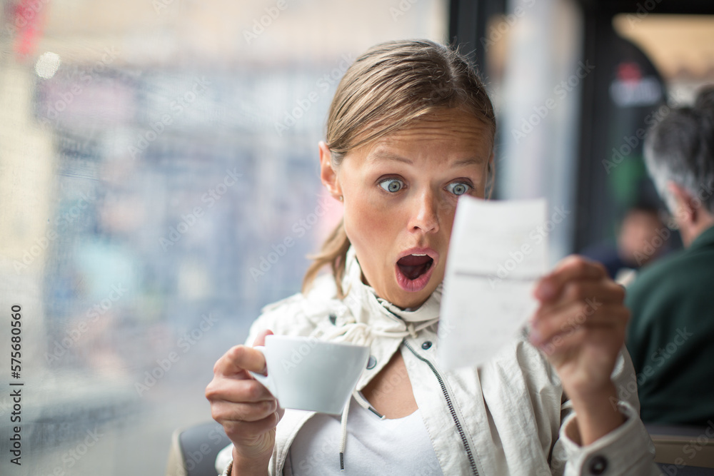 Ταπετσαρία Pretty, young woman baffled with the bill in a coffeeshop/restaurant