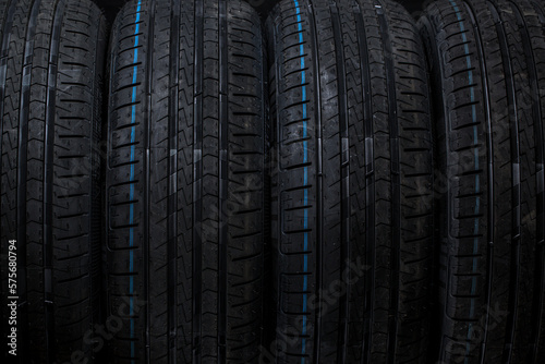 Stack of brand new high performance car tires on clean high-key white studio background © lightpoet