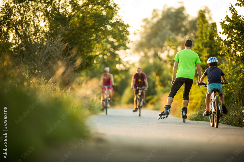 Fototapeta premium People doing sports on a biking path in the evening