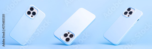 set of three iPhone 14 and 13 Pro Max in blue silicone case falling down in different angles, back view isolated on blue background, phone case mockup in monochrome colours