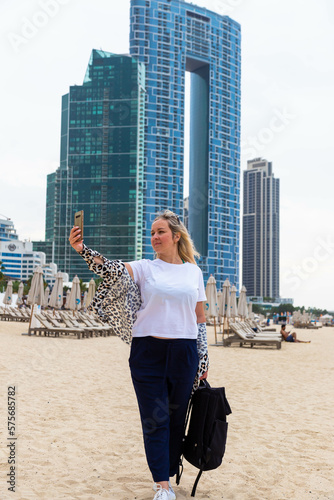 Photography beautiful blonde girl in dubai uae on the beach among modern architece