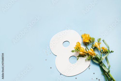 Fotografia number 8 shape layout with yellow flowers bouquet on blue background