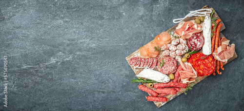 Italian meat platter prosciutto ham, salami, aperitivo party concept. Long banner format. top view photo