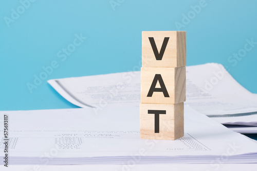 VAT - financial concept, wooden cubes on blue background